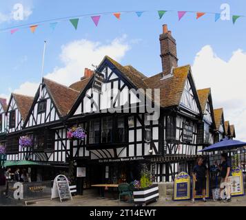 The Old Weavers House restaurant, AD 1500, Canterbury, Kent with bunting overhead and hanging baskets on the walls Stock Photo