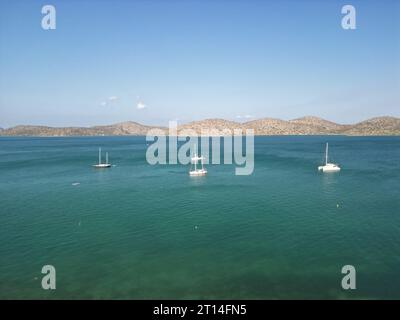 An aerial view of Elounda Bay on the Greek island of Crete with boats sailing along the shore Stock Photo