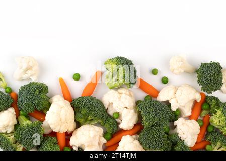 the mix raw vegetable. Flat lay of fresh raw organic vegetables on white background - broccoli, carrots, peas, cauliflower. Stock Photo