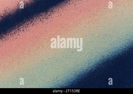 Macro close-up of a wall spray painted with diagonal dark blue, beige and yellow lines. Abstract colorful textured and splattered graffiti background. Stock Photo