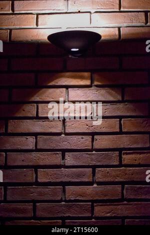 exposed brick wall illuminated by a two-way fixture Stock Photo