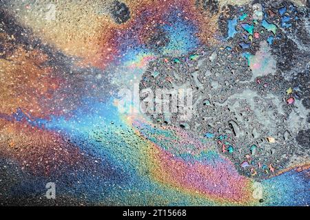 Colored oil stains close up, the color of the gasoline stain on the pavement road as a texture or background. Stock Photo