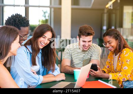 Multiracial group of happy friends studying in university - Young cheerful students having fun - Positive and education concept Stock Photo