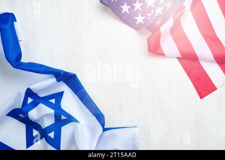 Israel USA flags. Two American and Israeli flags lie on white old concrete wall texture background opposite each other conveys partnership between two Stock Photo