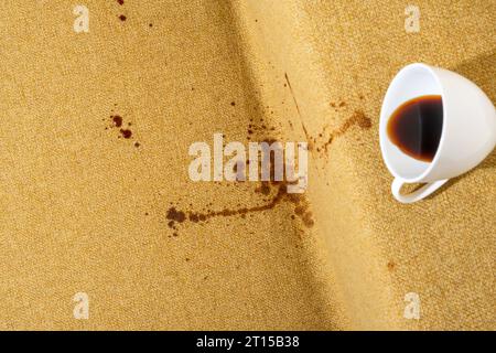 Accidental coffee spill on the sofa, creating a brown stain that marred the upholstery, sofa or couch. Spoiled fabric-covered. Cleaning and stain remo Stock Photo