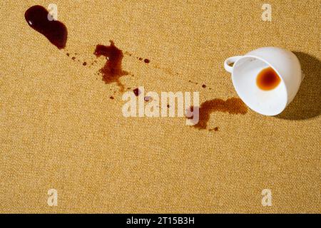 Spilled coffee on a yellow sofa, carpet or upholstery. Spoiled fabric-covered. Cleaning and stain removal concept Stock Photo