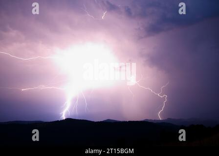 Lightning strike on the dark cloudy sky at night Stock Photo