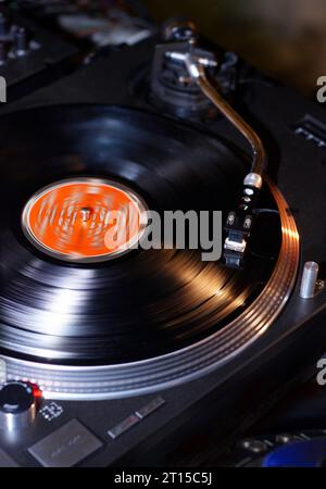 Dj turntables needle cartridge on black vinyl record with music. Close up, nobody, focus on turntable and audio disc record Stock Photo