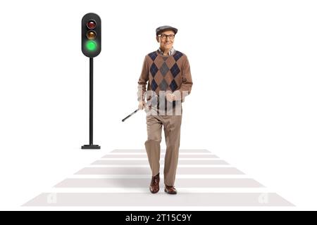 Happy elderly man walking at a pedestrian crossing and holding a cane isolated on white background Stock Photo