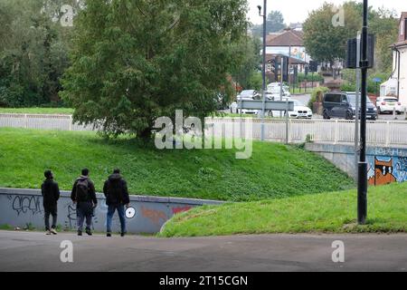 Three men walking through the underpass of the M32 flyover in Eastville,  Bristol. Stock Photo