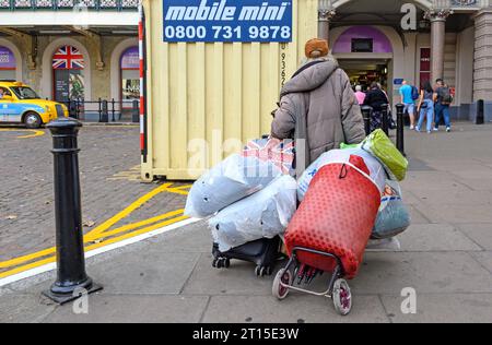 London, UK. Homeless women with her possessions on trolleys heading for Charing Cross Station Stock Photo