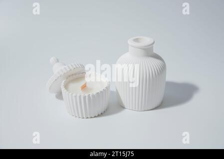 candle in white ceramic pot on a white background ,a vase with a candle.Cozy home natural eco decor Stock Photo