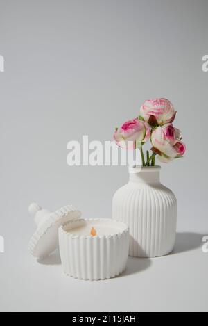 candle in white ceramic pot on a white background ,a vase with a candle.Cozy home natural eco decor Stock Photo