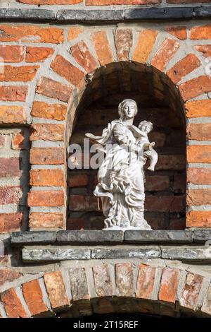Statue of Virgin Mary with Baby Jesus in alcove above entrance door at the 17th century Beguinage of Aarschot in Flemish Brabant in Flanders, Belgium Stock Photo