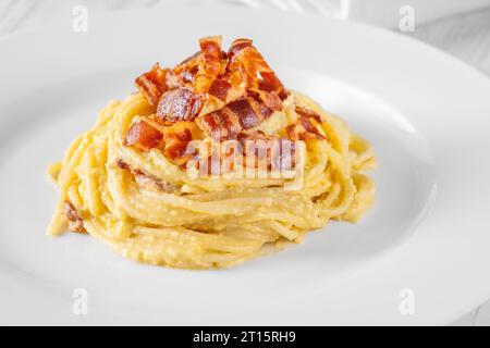 Portion of carbonara pasta garnished with fried guanciale Stock Photo