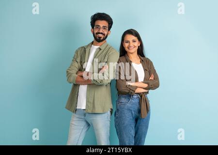 Smiling millennial eastern man and woman standing back to back Stock Photo