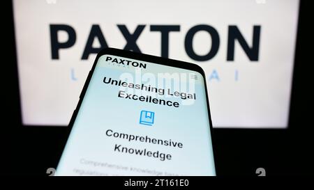Mobile phone with webpage of US legal artificial intelligence company Paxton AI Inc. in front of business logo. Focus on top-left of phone display. Stock Photo