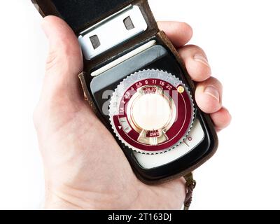 Old vintage photo exposure meter in hand photographer isolated white Stock Photo
