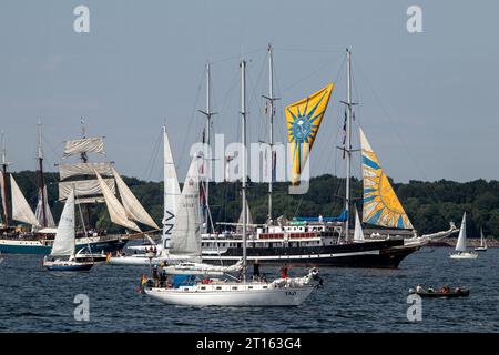 Kiel, Schleswig-Holstein, Germany. 24th June, 2023. The three-masted staysail schooner Capitán Miranda (center rear) with yellow-blue sails, launched in 1930, currently used as training ship of the Uruguayan Navy, takes part in Tall Ships Parade (Windjammerparade) in Kieler Förde bay of Baltic Sea with about 60 tall ships, traditional sailing ships, steamboats and hundreds of sailing yachts as part of the Kiel Week (Kieler Woche), an annual sailing event in Kiel. Stock Photo