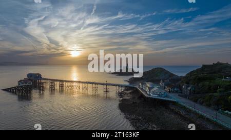 Editorial Swansea, UK - October 08, 2023: Sunrise over Mumbles lighthouse, pier and Beach Hut Cafe in Swansea, UK Stock Photo