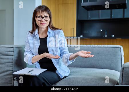 Portrait of female psychologist therapist with clipboard posing in office Stock Photo