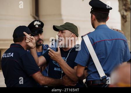 Reggio Calabria, Catanzaro, Italy. 11th Oct, 2023. Police seen holding a man who was provoking Lucano's supporter. The Court of Appeal of Reggio Calabria, guided by magistrate Elisabetta Palumbo, sentenced the former pro-migrant mayor Domenico Lucano to 1 year and six months of reclusion, with suspended pena. In October 2021, Lucano was sentenced by the Court of Locri to 13 years and two months of reclusion, for fraud and mismanagement of funds for migrants. (Credit Image: © Valeria Ferraro/ZUMA Press Wire) EDITORIAL USAGE ONLY! Not for Commercial USAGE! Stock Photo