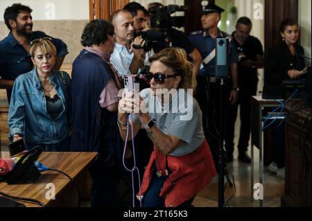 Reggio Calabria, Catanzaro, Italy. 11th Oct, 2023. A lady seen taking pictures of lawyers. The Court of Appeal of Reggio Calabria, guided by magistrate Elisabetta Palumbo, sentenced the former pro-migrant mayor Domenico Lucano to 1 year and six months of reclusion, with suspended pena. In October 2021, Lucano was sentenced by the Court of Locri to 13 years and two months of reclusion, for fraud and mismanagement of funds for migrants. (Credit Image: © Valeria Ferraro/ZUMA Press Wire) EDITORIAL USAGE ONLY! Not for Commercial USAGE! Stock Photo