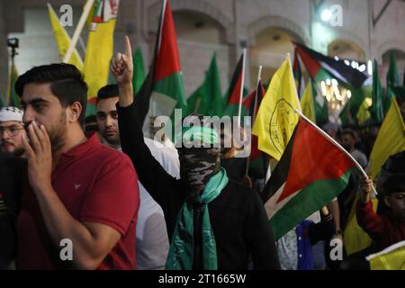 Palestinians waving national and Hamas flags shout slogans during rally ...