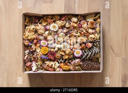 Dried rose flowers and petals in the cardboard box. Floral decor. Stock Photo