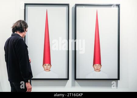 London, UK. 11th Oct, 2023. A gallery representative for Galerie Krinzinger Vienna with Marina Abramovic's 'Energy Hat (Eyes Open)', 2021/22. Frieze London, one of the most influential contemporary art fairs, opens its doors for the first preview day today. The 2023 edition marks the 20th anniversary of Frieze London. It runs 11-15 October in Regent's Park. Credit: Imageplotter/Alamy Live News Stock Photo