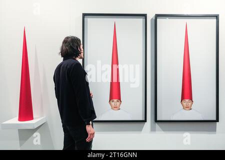 London, UK. 11th Oct, 2023. A gallery representative for Galerie Krinzinger Vienna with Marina Abramovic's 'Energy Hat (Eyes Open)', 2021/22. Frieze London, one of the most influential contemporary art fairs, opens its doors for the first preview day today. The 2023 edition marks the 20th anniversary of Frieze London. It runs 11-15 October in Regent's Park. Credit: Imageplotter/Alamy Live News Stock Photo