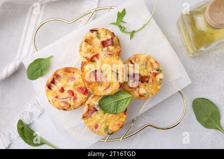 Freshly baked bacon and egg muffins with cheese on light gray table, flat lay Stock Photo