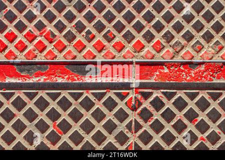 Metal stair treads with peeling red paint Stock Photo