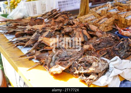 Smoked and grilled stingrays skewered on bamboo sticks sold in traditional markets are ready to eat. Pari fish. Batoidea is a superorder. Stock Photo