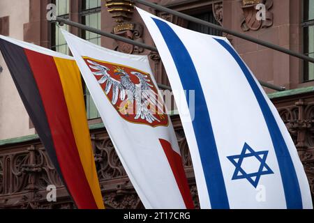 Solidarität mit Israel Am Balkon des Römers in Frankfurt am Main ist zusätzlich zur Deutschland-Fahne rechts sowie dem Frankfurter Stadtwappen Mitte aus Solidarität die Nationalflagge Israels gehisst. Am 07. Oktober 2023 hatte die radikalislamische Hamas von Gaza aus überraschend einen Angriff auf Israel begonnen. Frankfurt am Main Römerberg Hessen Deutschland *** Solidarity with Israel On the balcony of the Römer in Frankfurt am Main, in addition to the German flag on the right and the Frankfurt city coat of arms in the center, the national flag of Israel is hoisted in solidarity On 07 Octobe Stock Photo