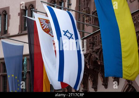 Solidarität mit Israel und der Ukraine Am Balkon des Römers in Frankfurt am Main sind zusätzlich zur Europa- und Deutschland-Fahne rechts sowie dem Frankfurter Stadtwappen Mitte aus Solidarität die Nationalflaggen Israels und der Ukraine rechts gehisst. Am 24. Februar 2022, begann die Invasion russischer Truppen in die Ukraine. Seitdem dauert der Angriffskrieg Russlands an. Am 07. Oktober 2023 hatte die radikalislamische Hamas von Gaza aus überraschend einen Angriff auf Israel begonnen. Frankfurt am Main Römerberg Hessen Deutschland *** Solidarity with Israel and Ukraine On the balcony of the Stock Photo