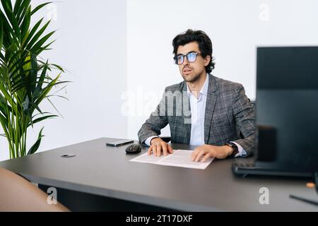 Portrait of confident concentrated male employee in business suit talk with unrecognizable colleague explain thought or idea. Focused businessman Stock Photo