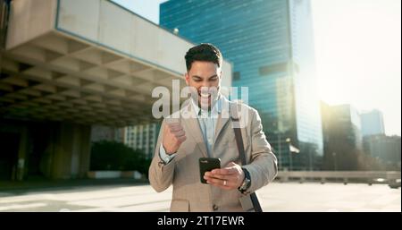 Walking, phone or happy businessman in city on social media, internet post or website notification. News, smile or Arabic entrepreneur on mobile app Stock Photo