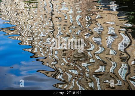 Old mill beside the Macclesfield canal, Cheshire, England, reflected in the water. Stock Photo