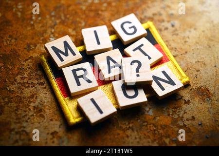 Schriftzug Migration und Fragezeichen auf Fahne von Deutschland, Symbolfoto Migrationskrise Stock Photo