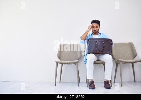 Bag, stress and man search in waiting room for interview, hiring and recruitment with lost resume in briefcase. Problem, finding and person forget Stock Photo