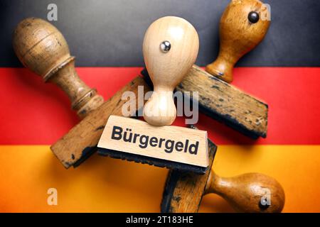 FOTOMONTAGE, Stempel mit der Aufschrift Bürgergeld auf deutschen Nationalfarben Stock Photo