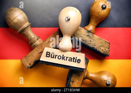 FOTOMONTAGE, Stempel mit der Aufschrift Bürokratie auf deutschen Nationalfarben Stock Photo