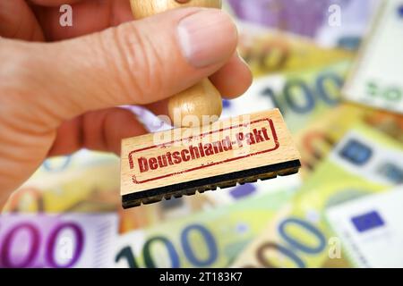FOTOMONTAGE, Hand hält Stempel mit der Aufschrift Deutschland-Pakt Stock Photo