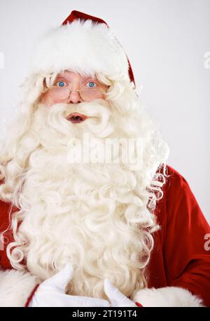 Santa claus, surprise and portrait in studio for Christmas celebration, season greeting or vacation joy. Male person, shock emoji face and red costume Stock Photo