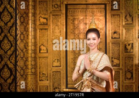 Smiling woman standing with her hands in prayer position, Thailand Stock Photo