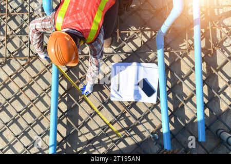 Overhead view of a building contractor checking foundations of a building, Thailand Stock Photo