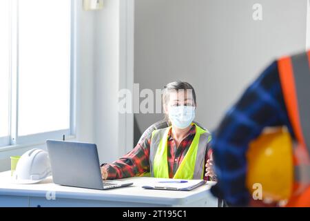Two building inspectors in an office discussing a construction project Stock Photo
