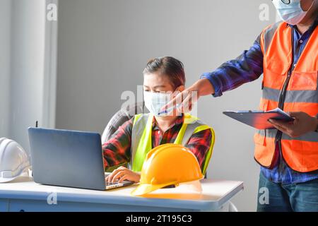 Two building inspectors in an office discussing a construction project Stock Photo