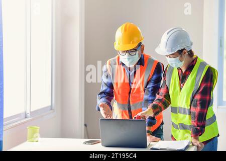 Two building inspectors in an office discussing a construction project Stock Photo